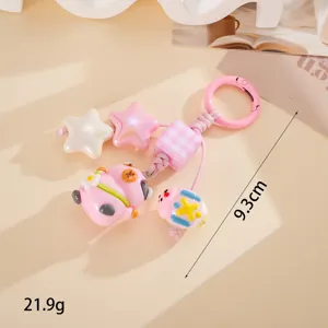 Détail du porte-clés loutre rose avec étoiles et perles, longueur 9,3 cm, 21,9 g.