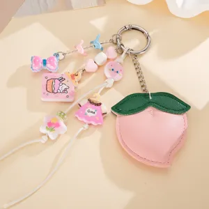 Gros plan d'un mignon porte-clés pêche en cuir avec des perles et breloques colorées