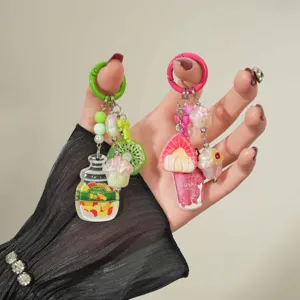 Close-up detail of sweet acrylic keychains with colorful fruit and candy jar charms