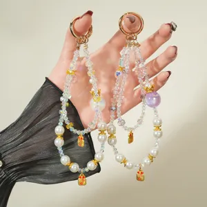 Detailed view of colorful beaded phone strap with pearls and crown charm