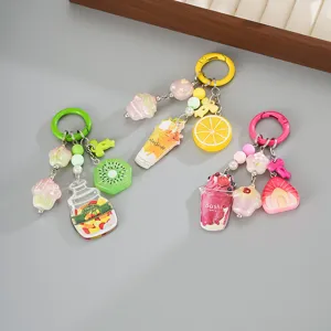 Detailed view of colorful acrylic fruit and ice cream charms on bag keychains.