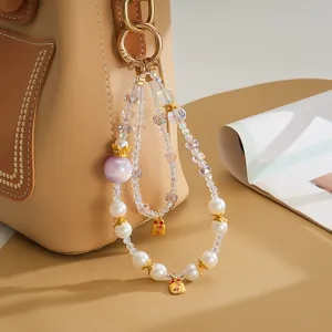 Close-up view of elegant double-strand beaded bag charm with pearl and crown details