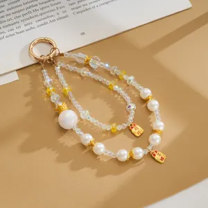 Exquisite detail of iridescent beaded phone strap featuring pearls and crown charm