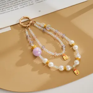 Detail view of double-strand beaded phone strap with iridescent beads and pearls