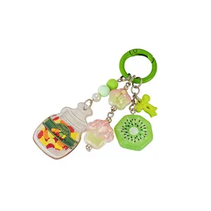 Detailed view of colorful acrylic fruit and candy jar charms on a green keychain