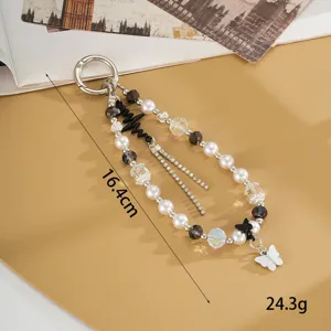 Détail d'une chaîne de téléphone perlée avec pendentif papillon et motif de rythme cardiaque