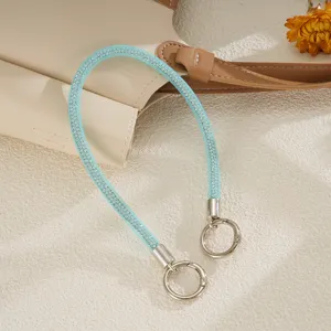 Close-up of a blue mesh rhinestone phone strap with silver circular carabiner clasps
