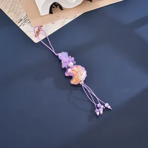 Detailed view of the purple beaded phone charm with embossed moon and floral elements