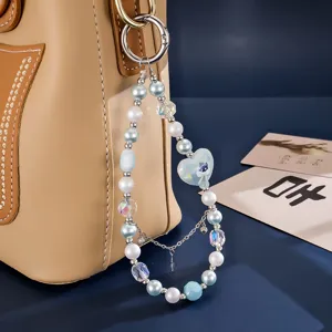 Macro view of an elegant blue and white beaded keychain with heart charm on tan handbag