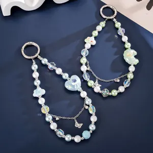 Detailed view of beaded wrist charms with moon, cloud, and butterfly pendants for bags or phones.
