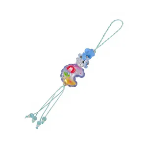 Detailed view of the cute candy color relief moon and beaded flower phone charm strap.