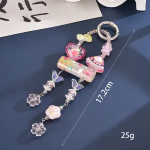 Detailed macro view of a candy-colored beaded bag charm with heart and butterfly shapes
