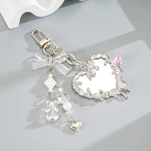 Llavero de espejo de corazón fluido plateado elegante con cristales rosas y gran lazo