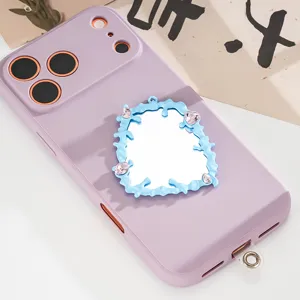 Primo piano di uno specchio blu a forma di cuore su una custodia per telefono lilla