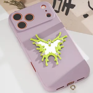 Close-up of irregular green butterfly charm with mirror and pink gems on phone case
