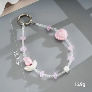 Detailopname van roze en witte kralen polsband met hart en bloem bedeltjes, 15,7 cm.