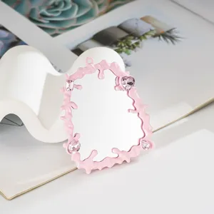 Dettaglio di specchio rosa con cornice fluida e gemme per decorazione cover cellulare fai-da-te