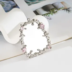 Dettaglio cornice a specchio in argento liquido con gemme rosa per decorazioni