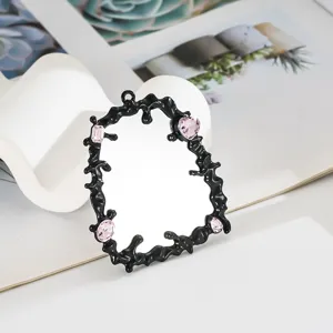 Dettaglio di una cornice fluida nera con gemme rosa per decorazione cover cellulare.