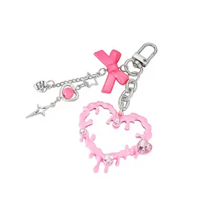 Detalle de un llavero de corazón rosa fundido con gemas y lazo decorativo para bolsos