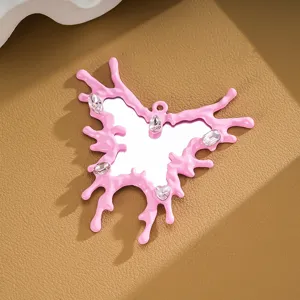 Pink butterfly mirror pendant with irregular dripping edge and sparkling gems.