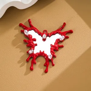 Close-up of a red irregular liquid butterfly pendant with mirror center and crystals