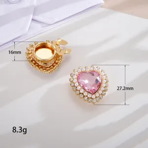 Vista dettagliata dei gemelli a cuore in cristallo rosa con perle e strass