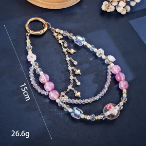 Detail of beaded phone strap with gold foil pink beads and heart charms