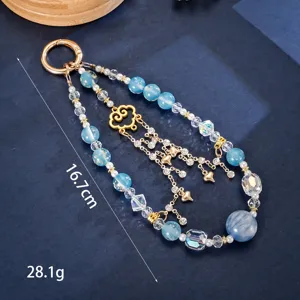 Detail of blue gold foil beaded phone charm with heart and butterfly pendants