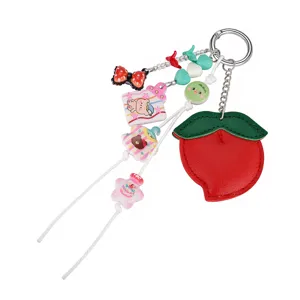 Détail d'un joli porte-clés en cuir PU en forme de pêche avec divers charms en acrylique