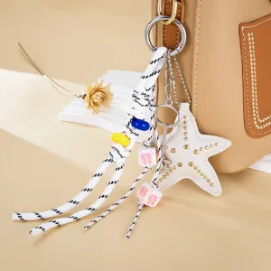 Detail des perlenbesetzten Miu-Stil Taschenanhängers mit Stern und Nieten auf Tasche