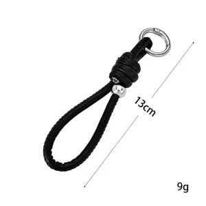 Detailed view of hand-woven black leather cord keychain with silver bead and 13cm length