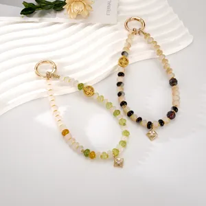 Detail showing two New Chinese style beaded phone charms with gold floral pendants