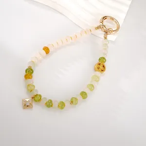 Detail view of New Chinese style beaded phone charm with gold square pendant