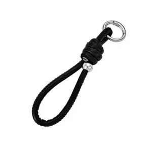 Detailed macro view of black braided leather keychain with silver bead and circular clasp