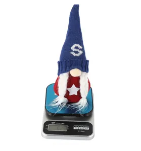 Close-up detail of the patriotic gnome doll with knit hat and star on a weighing scale.