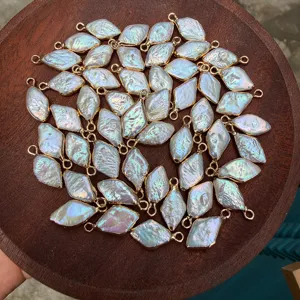 Detailed view of diamond-shaped baroque freshwater pearl pendants with gold edges