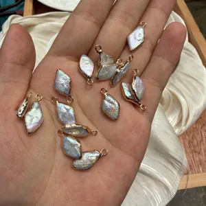 Detailed view of diamond-shaped baroque pearls with gold-plated frames on hand