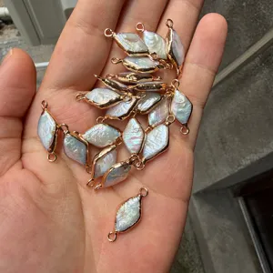 Macro view of marquise Baroque pearl pendants with gold-plated edges and double loops