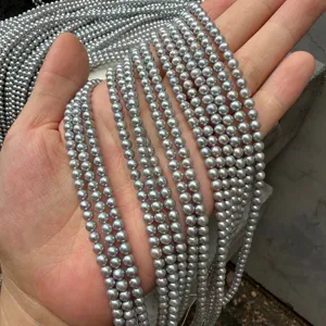 Detailed macro view of 4mm near-round grey freshwater pearls strands held in palm