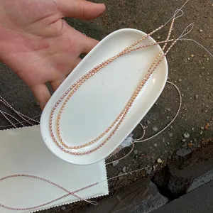 Nahaufnahme von 2-2,5 mm natürlichen Mini-Süßwasserperlen auf einem weißen Porzellanteller