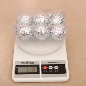 Vue détaillée du poids de 6 boules disco argentées en boîte transparente pour sapin de Noël.