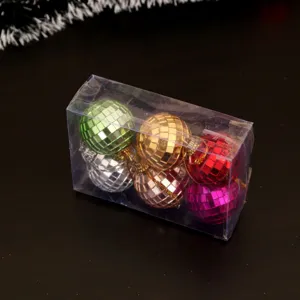 Gros plan de boules disco à miroir colorées dans une boîte transparente pour sapin.