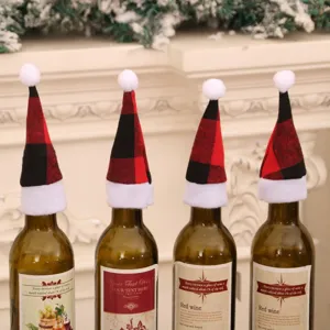 Vista dettagliata di mini cappelli natalizi a quadri rossi e neri per le bottiglie di vino.