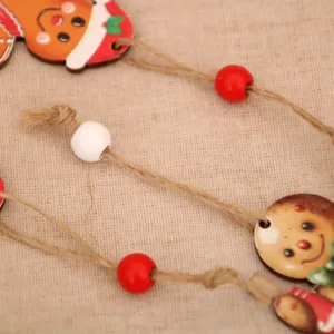Weihnachten Holz Dekoanhänger Detail mit Lebkuchenmann und bunten Perlen für Christbaumschmuck.