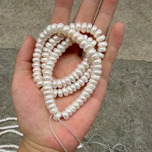 Close-up of 8-9mm natural abacus-shaped pearls held in hand for detail