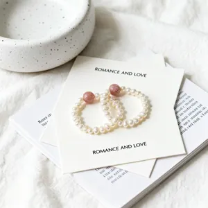Detailed close-up view of freshwater pearl elastic rings with pink strawberry quartz beads.