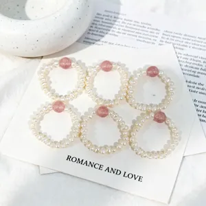 Close-up detail of sweet elastic freshwater pearl rings with pink strawberry crystal beads