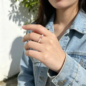 Detail view of a dainty elastic ring made with freshwater pearls and strawberry quartz.