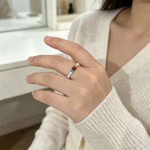 Detailansicht eines handgefertigten elastischen Perlenrings mit rotem Achat und Türkis